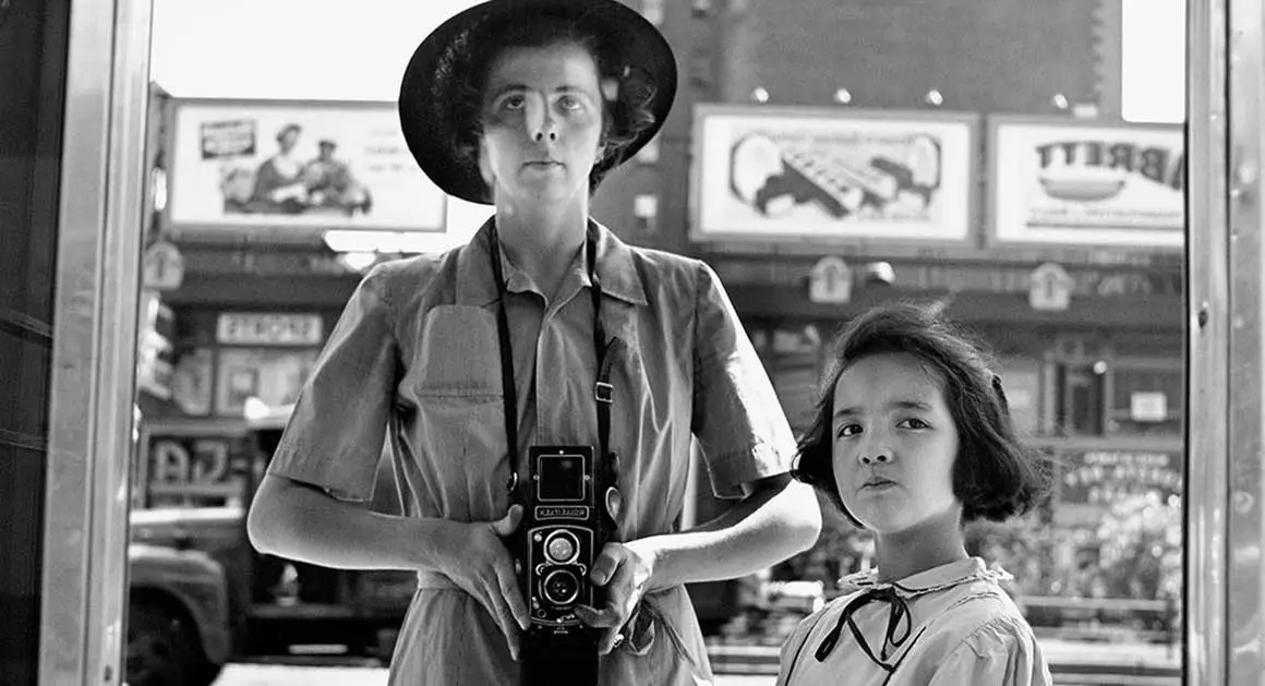 Vivian Maier photographing herself and a child